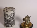 un petit vase et une petite statue posés sur une table