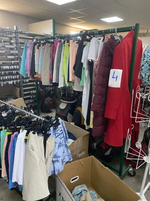 une pièce remplie de nombreux vêtements et d'un portant à vêtements