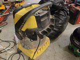une machine jaune et noire dans un garage, à côté d'autres outils