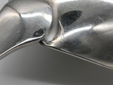 a silver bird shaped object on a white surface