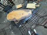 Plusieurs morceaux de bois sont posés sur un support métallique dans une pièce.