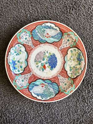 une image représentant une assiette rouge et blanche ornée de fleurs
