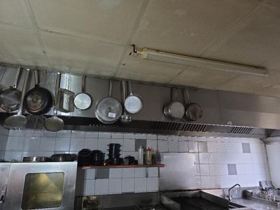 des casseroles et des poêles suspendues au plafond d'une cuisine