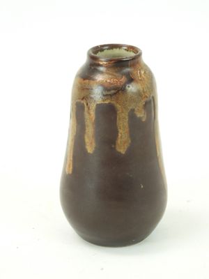 a brown vase that is sitting on a white surface