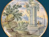 a plate with a painting on it on a blue surface