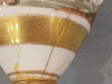 a white vase with a gold and white design on it