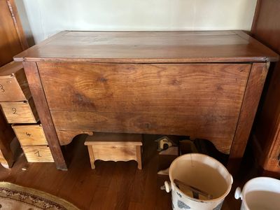 une table en bois avec des tiroirs et un seau posé par terre