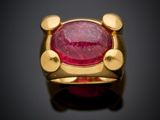gros plan d'une bague en or avec une pierre en rubis