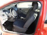 a red car with a black seat cover and a steering wheel