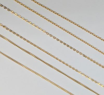 a collection of gold chain necklaces on a white background