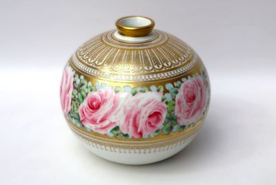 a white and gold vase with pink roses painted on it
