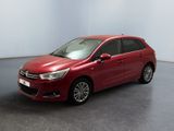 La voiture rouge est garée dans une pièce aux murs blancs.