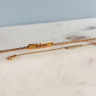 un gros plan sur un bracelet en or sur lequel est gravé un prénom