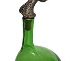 a green glass bottle with a bird on top of it