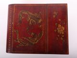 a red book with a dragon and flowers on it