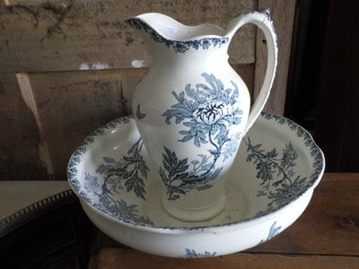 a blue and white pitcher and bowl sitting on a table