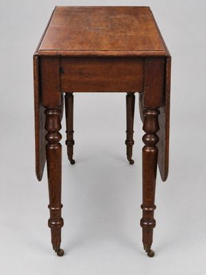 une vieille table en bois aux pieds tournés et au petit plateau