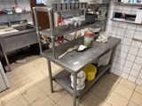 une cuisine avec une grande table en métal sur laquelle sont posés de nombreux plats