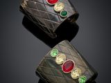 a pair of gold and emerald cuff bracelets