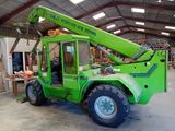 a green crane that is parked inside of a building