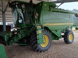 un gros tracteur vert garé sous une structure métallique