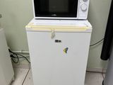 a microwave sitting on top of a refrigerator in a kitchen