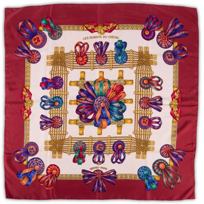 a red and white square scarf with colorful designs on it