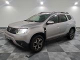 une Dacia grise garée dans une pièce au sol en damier