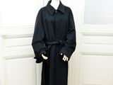un mannequin vêtu d'un manteau noir et d'un chapeau