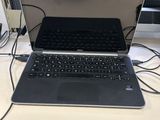 un ordinateur portable posé sur un bureau à côté d'un moniteur