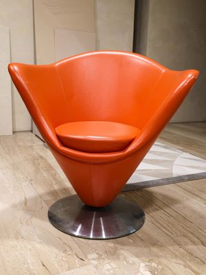 an orange chair that is sitting in a room