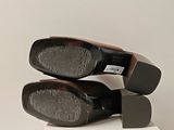 two pairs of black shoes sitting on top of a white box