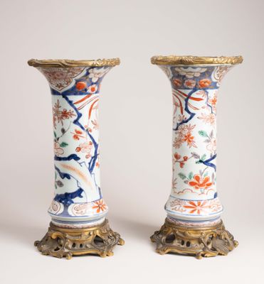 une paire de vases anciens ornés de motifs floraux sur fond blanc