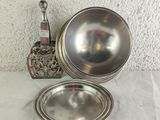a silver bowl and a silver plate on a table