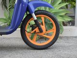a blue and orange scooter parked in front of a building