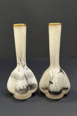 deux vases blancs ornés de motifs noirs et blancs, posés sur une table