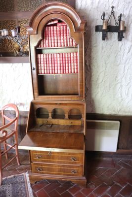 a wooden cabinet with a book shelf on top of it