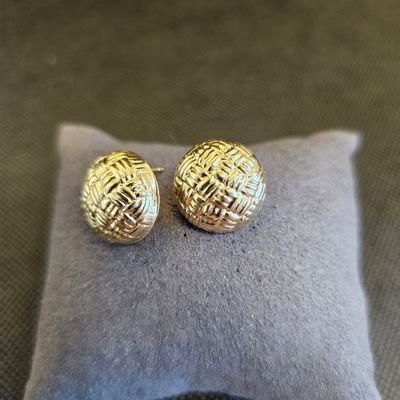 un gros plan sur une paire de boucles d'oreilles posées sur un oreiller
