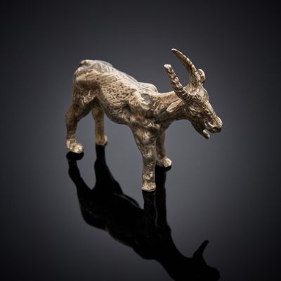an image of a goat figurine on a reflective surface