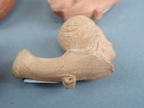two clay figurines on a table with one of them holding a knife