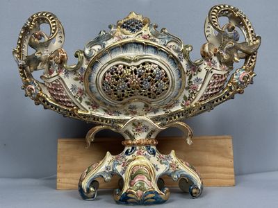 un vase décoratif posé sur un socle avec une base en bois