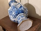 a blue and white vase sitting on a wooden table