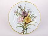 l'image d'une assiette avec des fleurs sur une surface blanche