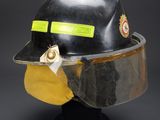 a close up of a black fireman ' s helmet with a yellow visor