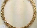 a close up of a gold necklace with a tag on it