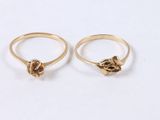 two gold rings with a knot on the top and a knot on the bottom