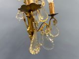a gold chandelier with crystal drops hanging from it