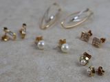 several pairs of earrings are laying on a table next to each other