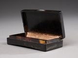 a small black box with a gold lid