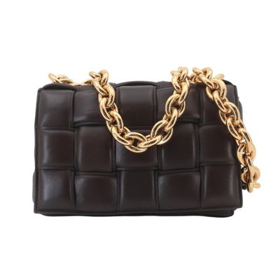 un sac à main noir orné de chaînes dorées et d'une chaîne qui l'entoure